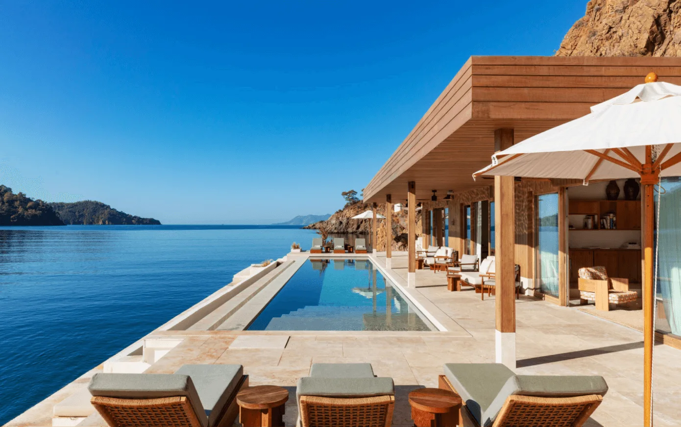 Ahama's poolside terrace above the sea, with loungers and a timber pavilion