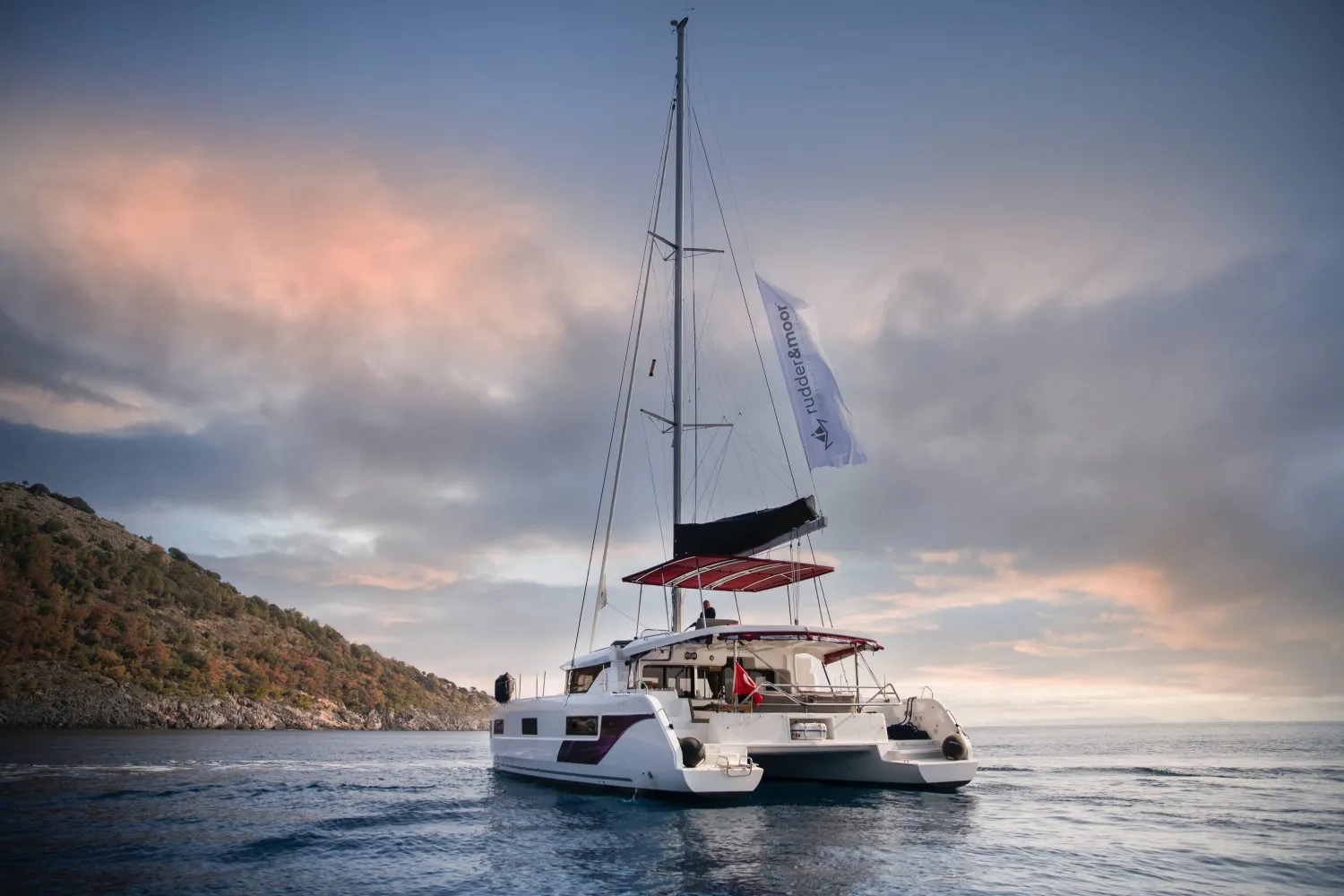 A Rudder & Moor catamaran at anchor off the Turkish coast at dusk